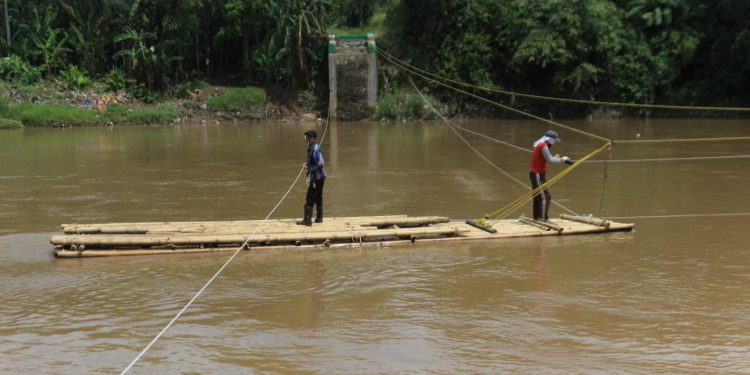 Jembatan Pelangi Roboh, Warga Gunakan Rakit Buatan Bah Iyeh Sebrangi Sungai Cimandiri